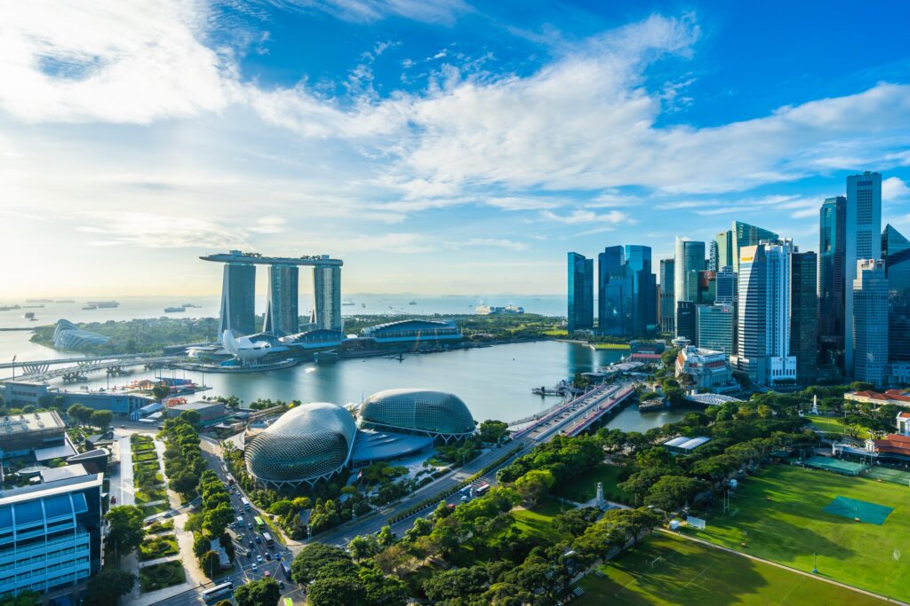 Aerial view of Singapore skyline featuring Marina Bay Sands, Esplanade, and lush green spaces